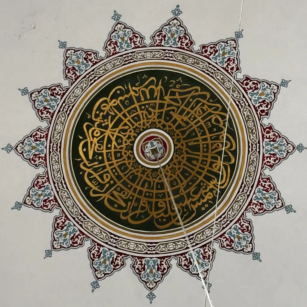 Nişancı Mehmed Paşa Camii'nde kubbe göbeği; koyu yeşil zemin üzerine altın yazılı daire, çevresinde kırmızı ve lacivert kalem işi yıldız.