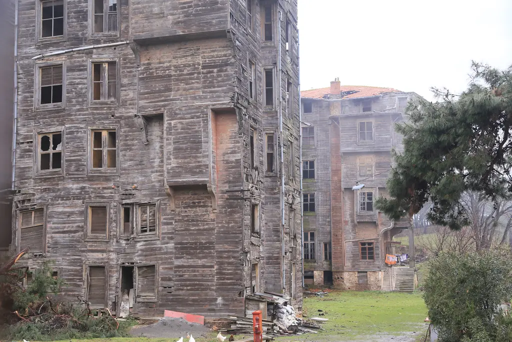 Büyükada Rum Yetimhanesi'nin cephesi; boyası dökülmüş ahşap kaplama, sıra sıra pencereler ve otlarla kaplı bahçe.