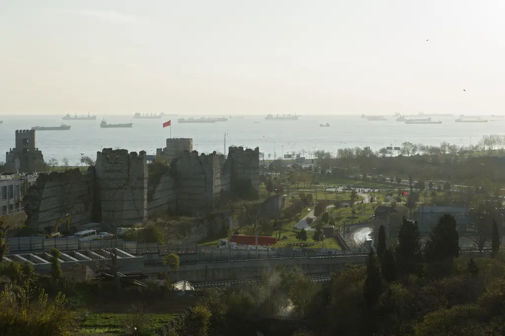 Yedikule Hisarı'ndan güneye bakış; Theodosius surlarının denize inen son bölümü, kıyıdaki Mermer Kule, önde sahil yolu ile demiryolu hattı ve arkada gemilerle dolu Marmara.
