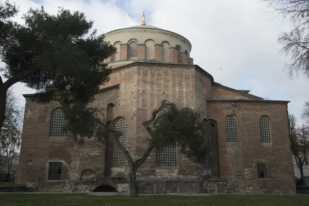 Güneydoğu cephe; öne çıkan yarım daire apsis, üzerindeki kemerli pencereler, çıplak ağaçlar ve arkada yükselen ana kubbe.
