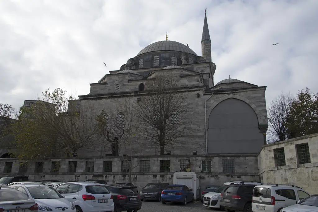 Gazi Atik Ali Paşa Camii'nin kıble yönü; büyük kubbe, mihrap çıkıntısını örten yarım kubbe, taş cephe ve önde park etmiş arabalar.
