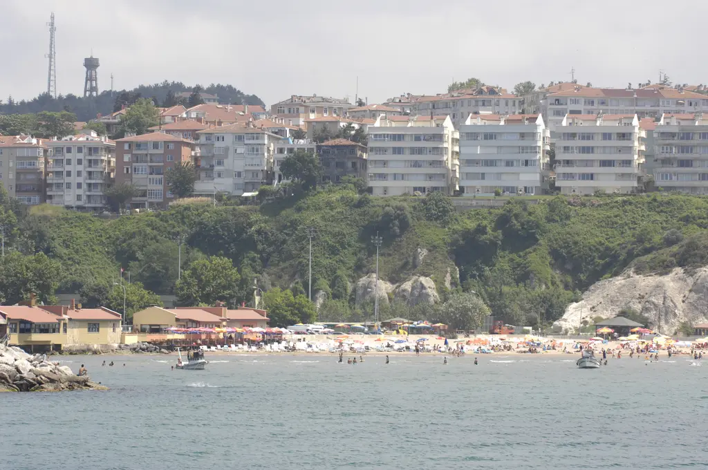 Şile'de kasabanın altındaki plaj; kalabalık kumsal, denizde yüzenler, kıyıda lokantalar ve yamaçta beyaz apartmanlar.