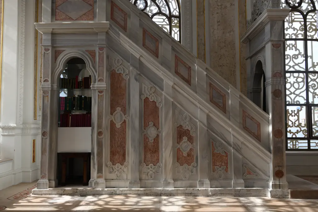 Ortaköy Camii'nin minberi; mermer merdiven, pembe taşlarla süslü yan ayna, korkuluk ve tepede külahlı köşk.