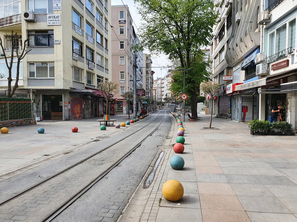 Kadıköy'de Bahariye Caddesi; tramvay rayları, renkli toplar, iki yanda apartmanlar ve ağaçlar.