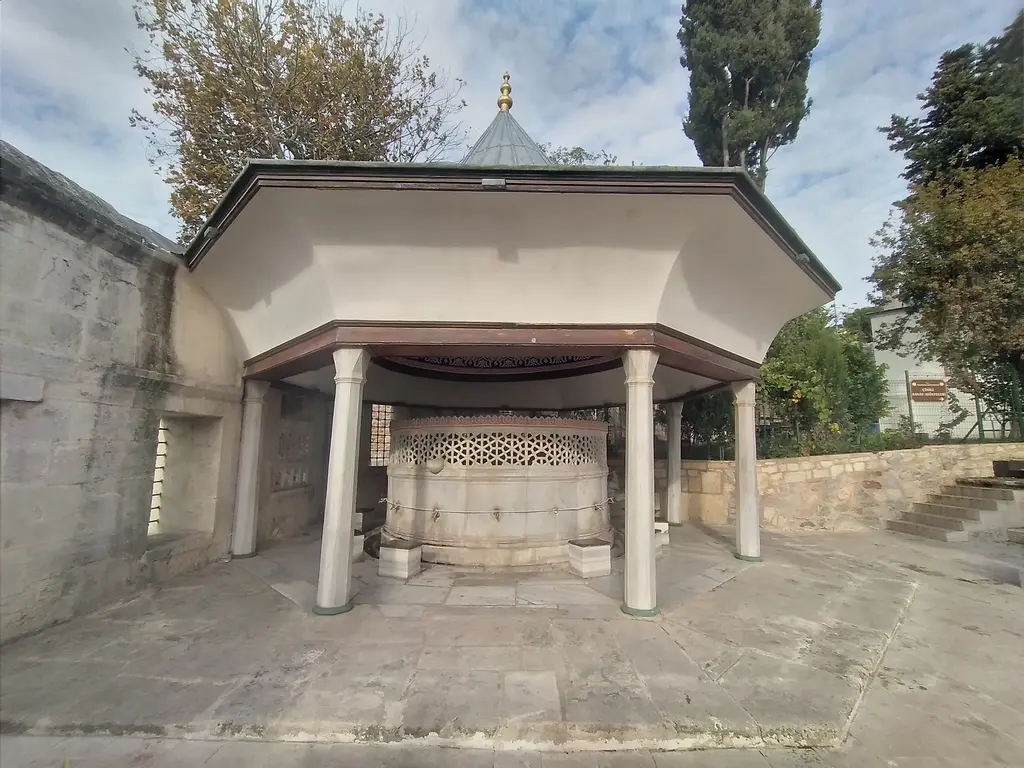 Çinili Camii'nin şadırvanı; ince sütunlara oturan geniş saçaklı çatı, altında mermer hazne ve kafes kubbe.