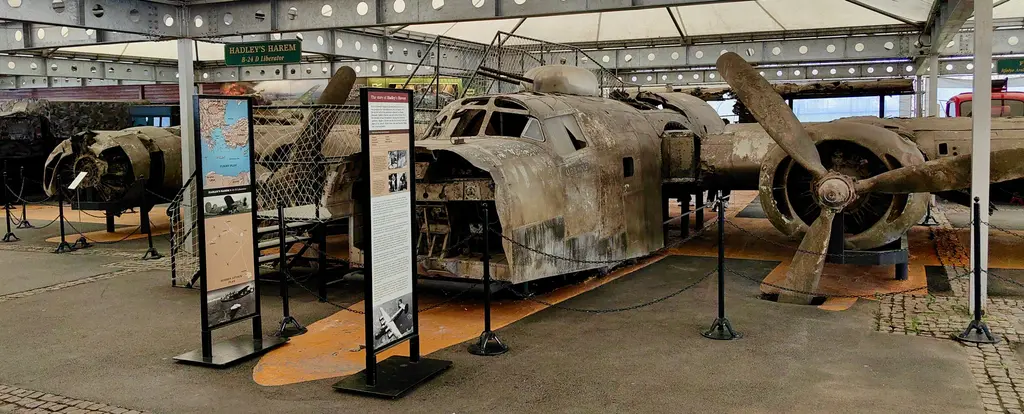 Rahmi Mustafa Koç Müzesi'nde B-24 Liberator kalıntısı; çürümüş metal gövde, motorlar, pervaneler ve çevresinde bilgi panoları.