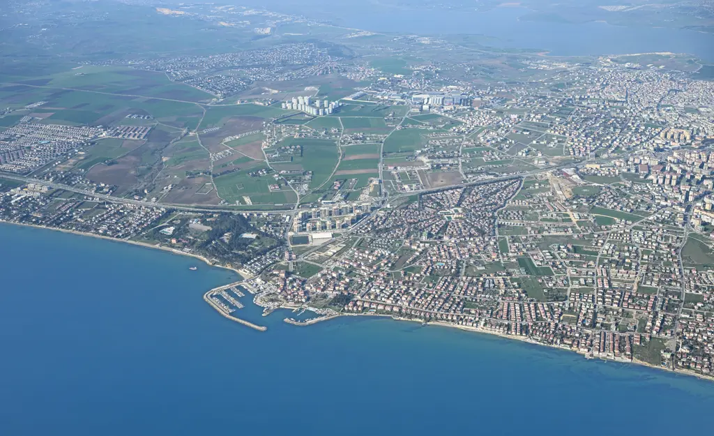 Havadan Büyükçekmece kıyısı; Marmara boyunca uzanan yerleşim, küçük bir liman, tarlalar ve mavi deniz.