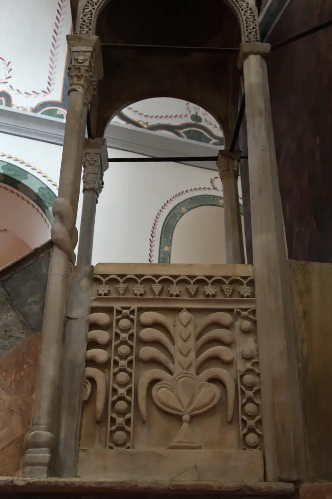 Zeyrek Camii'nde minber köşkünün yakın planı; mermer korkulukta palmet oymaları, üstte üzüm ve rozet dizisi, ince sütunlar ve arkada yeşil kırmızı kalem işi kemerler.