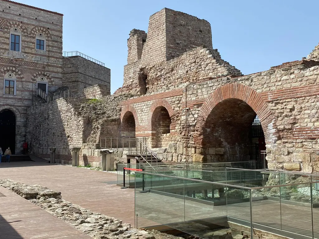 Tekfur Sarayı'nın avlusunda cam örtü altına alınmış kazı alanı; taş temel duvarları, tuğla kemer kalıntıları ve solda saray gövdesi.