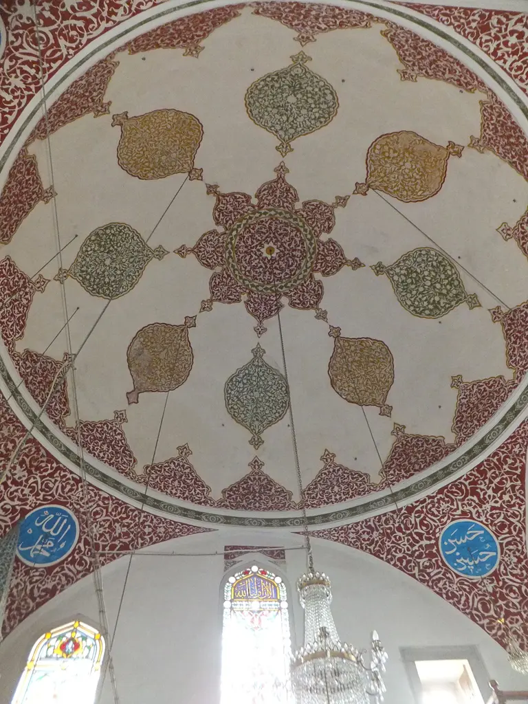 Çinili Camii'nin kubbesi; beyaz zemin üzerinde kırmızı ve yeşil kalem işi madalyonlar, altta pencereler.