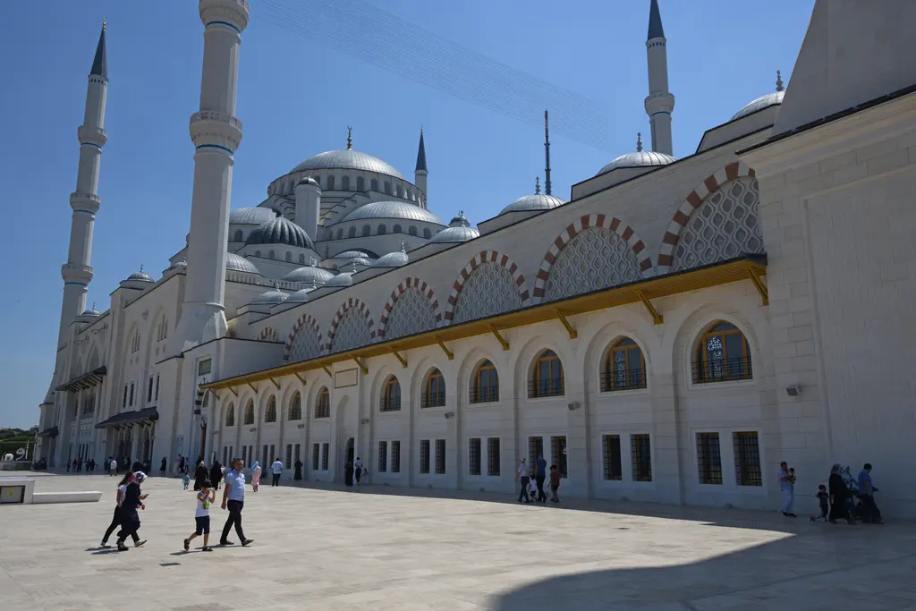 Üsküdar'da Büyük Çamlıca Camii; beyaz taş cephe, kemerli pencereler, kubbe kümesi ve gökyüzüne yükselen minareler.