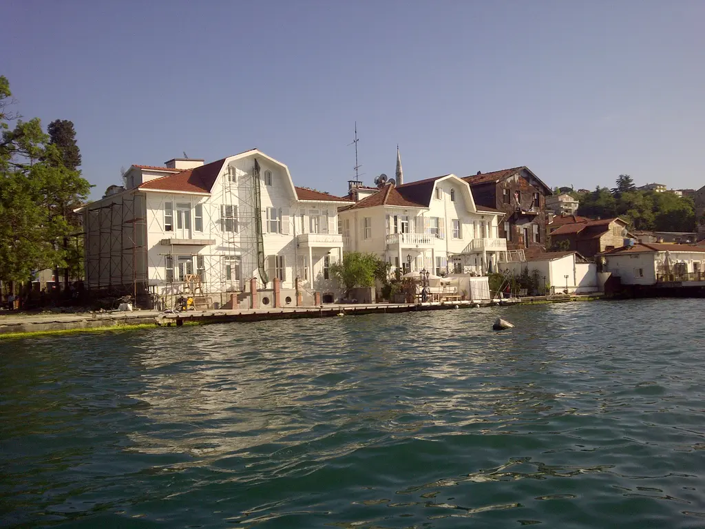 Paşabahçe'de yalılar; Boğaz kıyısında sarı ve beyaz cepheli büyük yalılar, önlerinde dalgalı deniz.