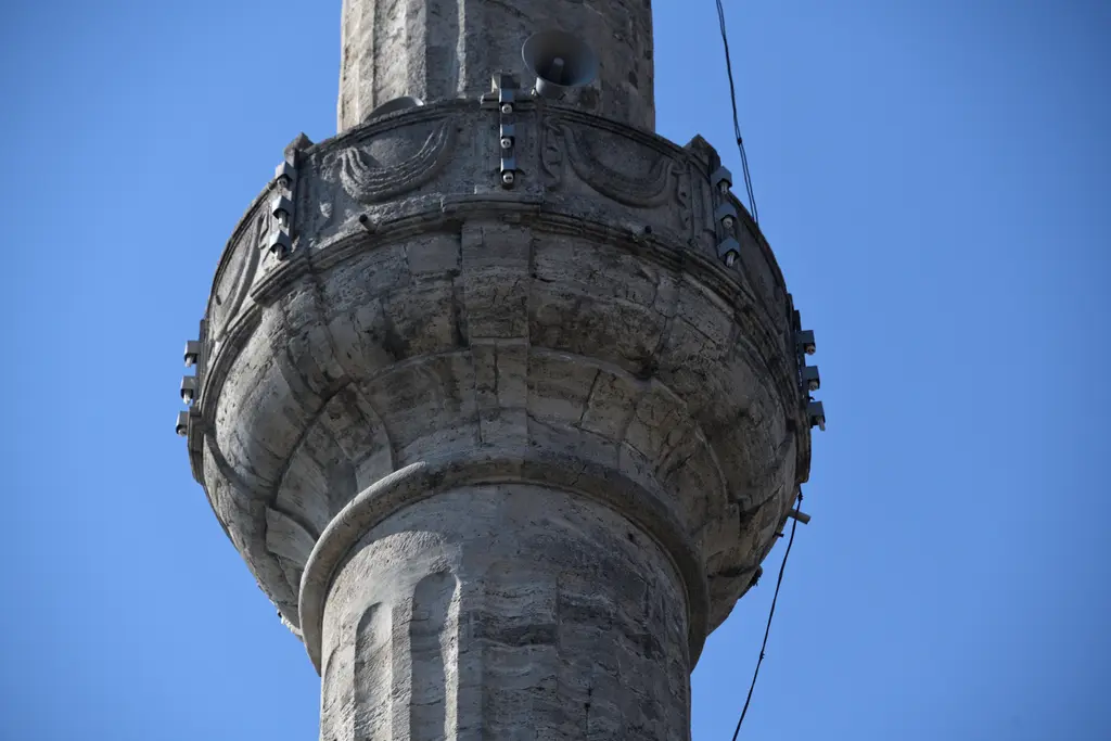 Selimiye Camii'nin minaresi; aşağıdan bakışla taş gövde, oyma korkuluklu şerefe ve mavi gökyüzü.