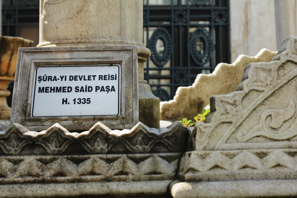 II. Mahmud Türbesi hazirede bir lahit; "Şura-yı Devlet Reisi Mehmed Said Paşa H. 1335" yazılı levha, oyma dilimli mermer kenar ve arkada şebeke.