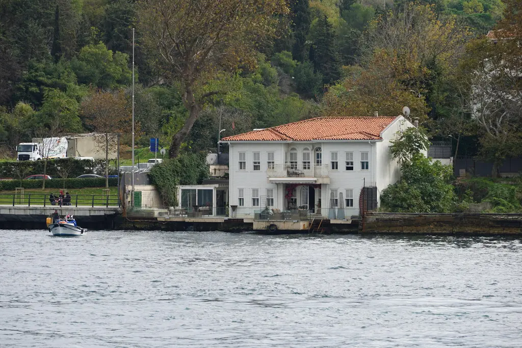 Kuzguncuk'ta Boğaz kıyısındaki Hafız Ahmet Paşa Yalısı; beyaz cephe, kiremit çatı ve önde su.