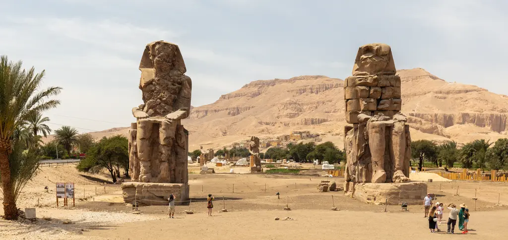 Memnon Heykelleri; ovada yan yana oturan iki dev taş firavun heykeli.