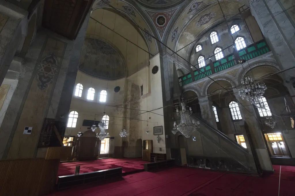 Gül Camii'nin harimi; mermer taklidi boyalı masif payeler, yeşil korkuluklu üst galeriler, kristal avizeler, sağda minber ve kırmızı halı.
