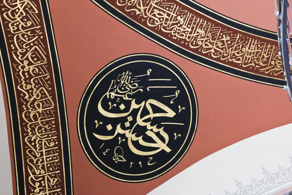 Şakirin Camii'nde kubbe süslemesi; kırmızı zemin üzerinde siyah yuvarlak madalyonda altın hat ve yazı kuşağı.