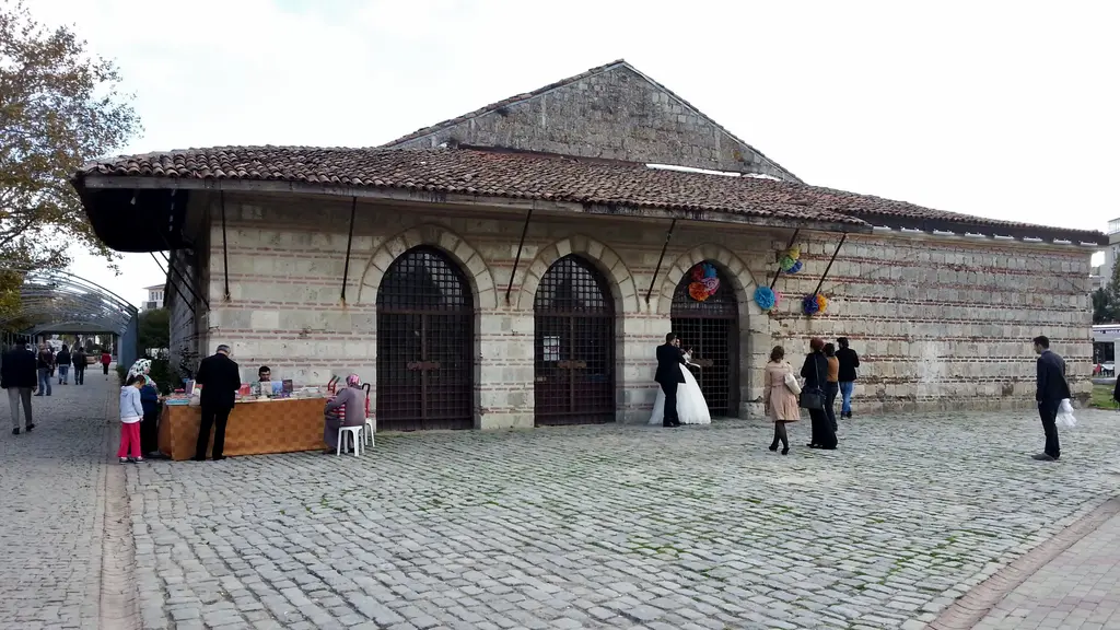 Büyükçekmece'de Kurşunlu Han; kesme taş ve tuğla duvarlı uzun yapı, kemerli pencereler, geniş çatı ve önündeki meydanda insanlar.