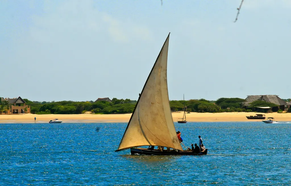 Lamu'da eski şehir ve dhow teknesi; taş cepheli Svahili evleri ve üçgen yelkenli ahşap tekne.