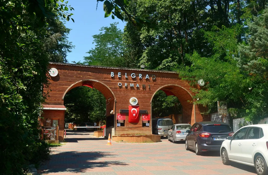 Belgrad Ormanı'nın Bahçeköy'deki ana giriş kapısı; tuğla kemerli kapı, önünde park etmiş araçlar ve ağaçlar.