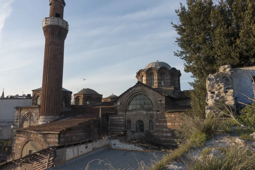 Vefa Kilise Camii çatı kotundan altın saatte; solda tuğla minare, ortada kasnağı üstünde ana kubbe, arkada iki küçük kubbe, sağda batı alınlığının kemerli penceresi.