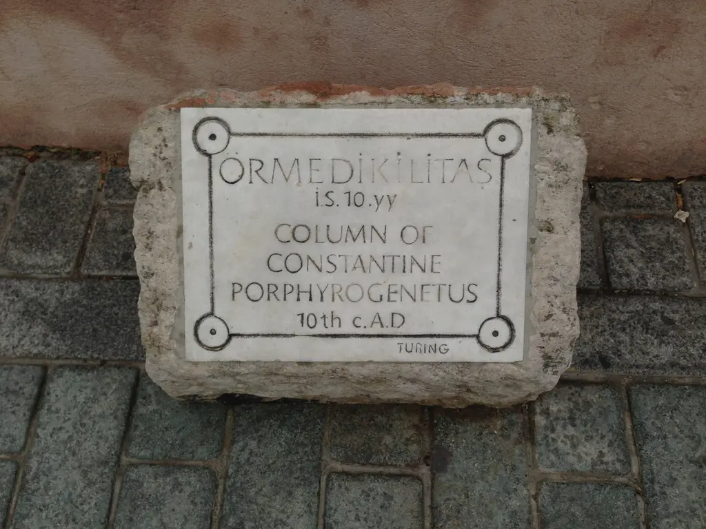 Örme Sütun'un mermer tanıtım levhası; "Örme Dikilitaş, İS 10. yy, Column of Constantine Porphyrogenitus" yazısı ve taş zemin.