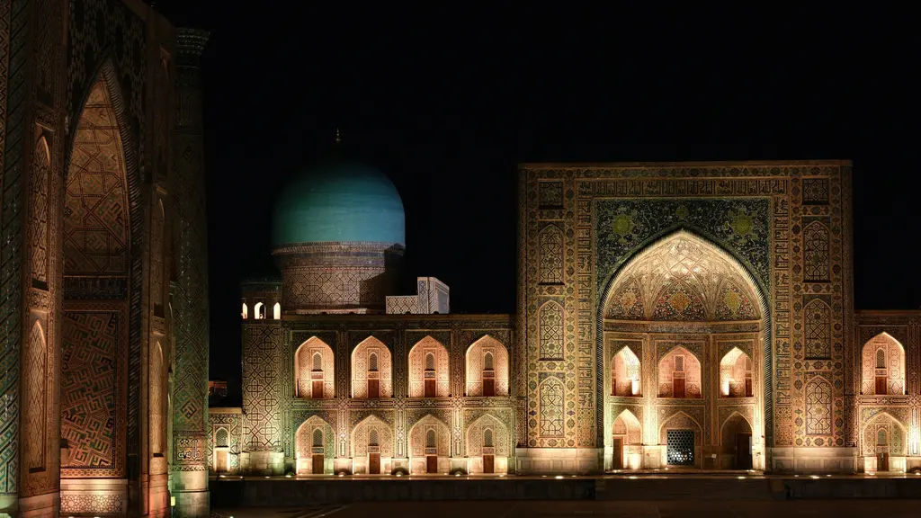 Semerkant'ta gece aydınlatmasıyla parlayan Registan Meydanı; ışıkla vurgulanan çini portaller, mavi kubbeler ve karanlık gökyüzü.