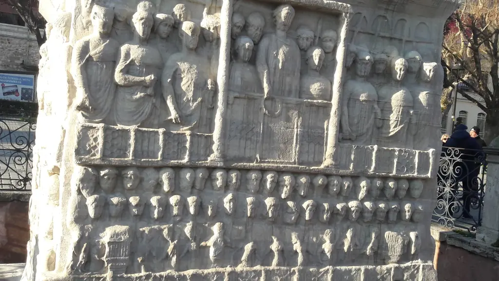 Dikilitaş'ın mermer kaidesinde kabartma; ortada sütunlar arasında imparator locası, çevresinde sıra sıra figürler, önde demir parmaklık.