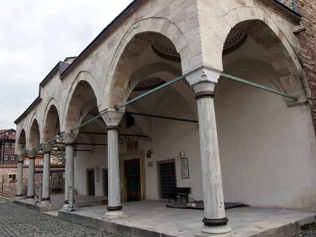 Küçük Ayasofya Camii'nin son cemaat yeri; mermer sütunlara oturan beş sivri kemer, kurşun tonozlar, yeşil boyalı işlemeli ahşap kapı, mermer seki ve önde arnavut kaldırımı avlu.