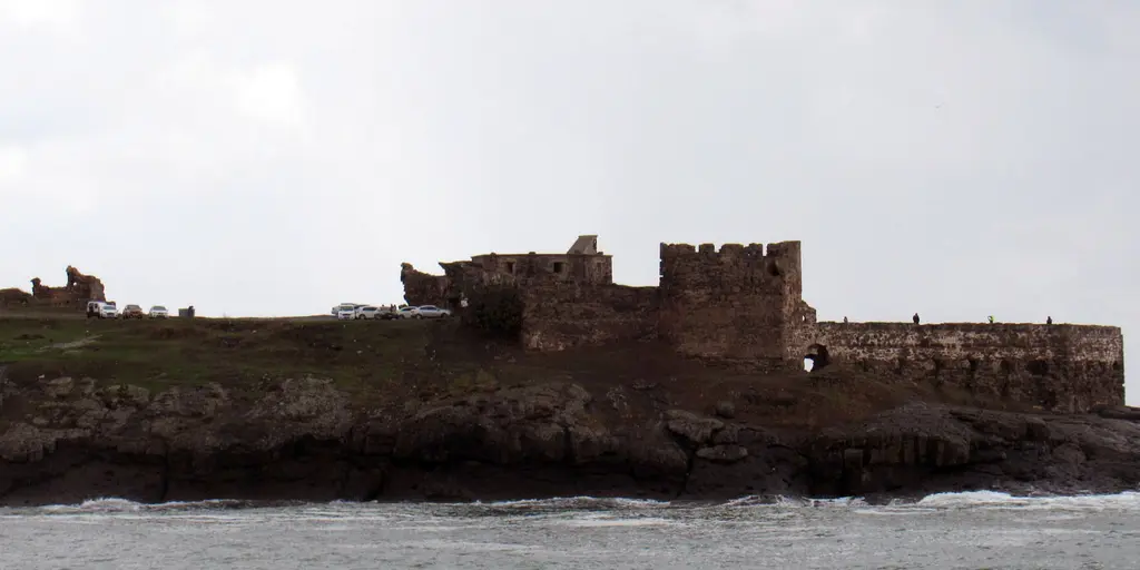 Rumeli Feneri Kalesi denizden; kayalık burnun üstünde alçak taş surlar, burçlar ve önde dalgalı deniz.