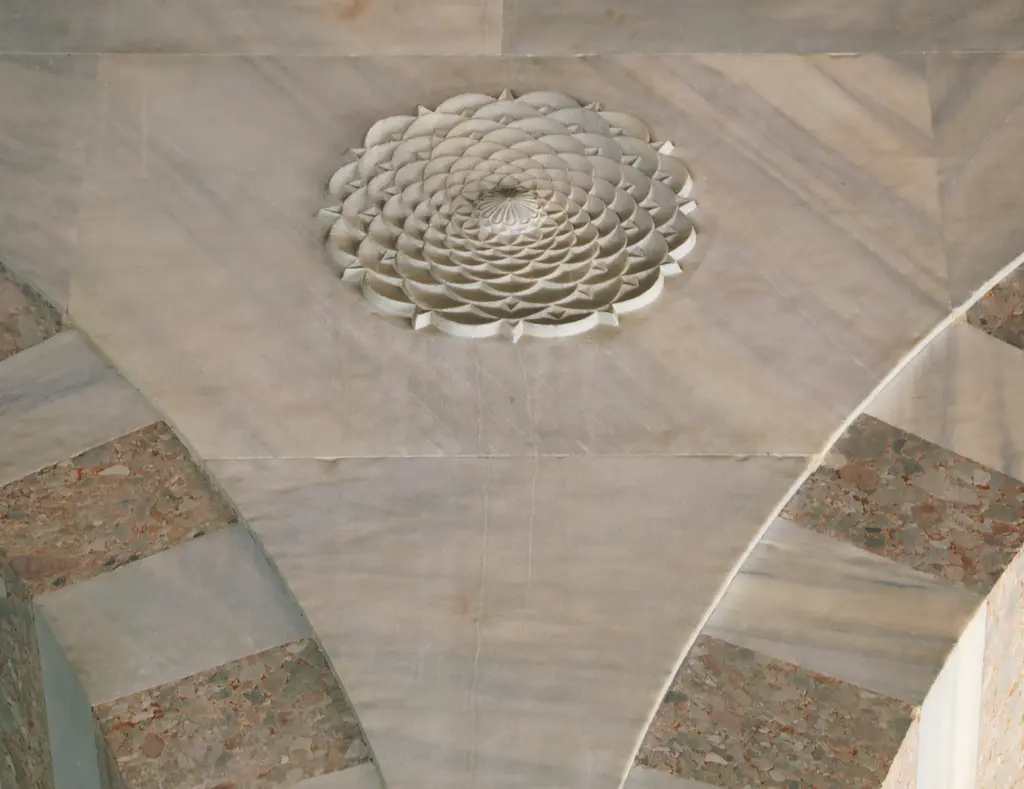 Atik Valide Camii'nin revakında taş rozet; kemerlerin arasında yaprak dilimli kabartma bir süs.