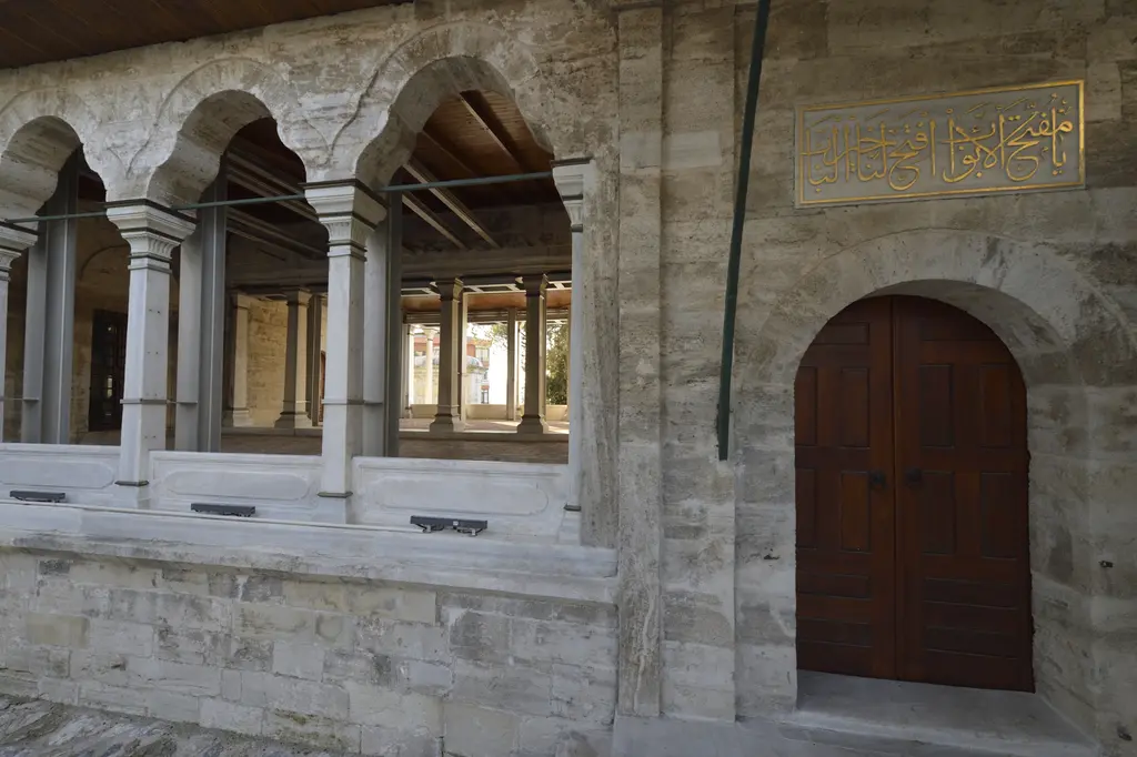 Ayazma Camii'nde hünkâr köşkünün galerisi; ince sütunlara oturan kemerler, mermer korkuluk ve ahşap kapı.
