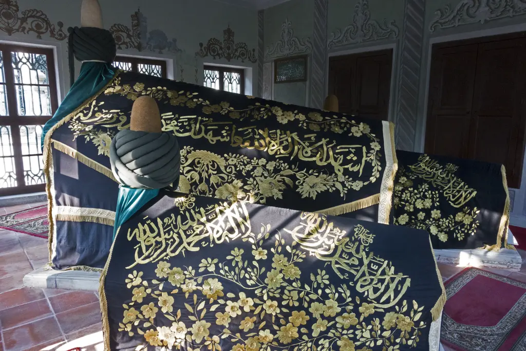 Şeyh Galip Türbesi'nin içinde yeşil sikkeli sandukalar; üzerlerinde altın işlemeli siyah örtüler.