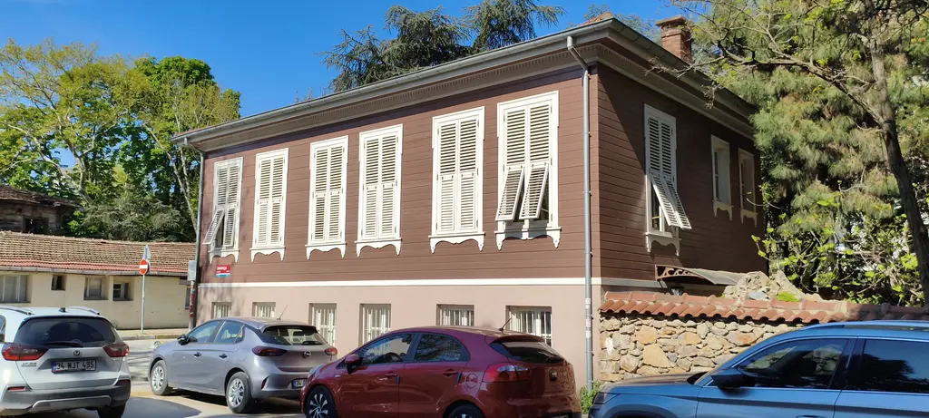 Göztepe'de Rıdvan Paşa Sokağı'nda köşk; kahverengi ahşap cephe, beyaz kepenkli pencereler ve taş duvar.