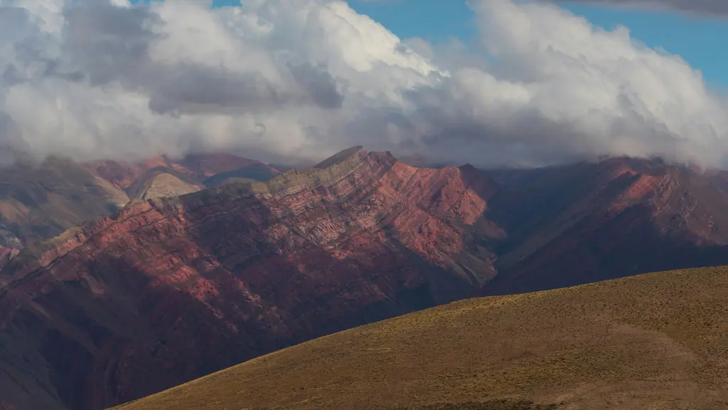 Humahuaca Vadisi; renkli katmanlı kayalık yamaçlar, kurak vadi tabanı ve yol.