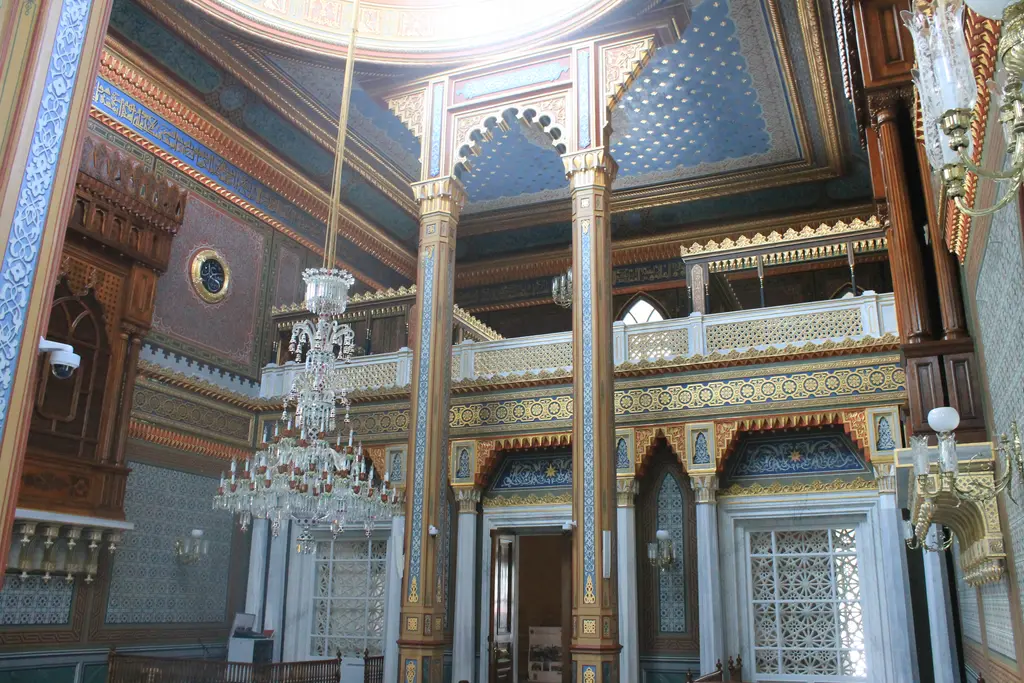 Yıldız Hamidiye Camii'nde kafesli mahfil ve kristal avize; ince kolonlar, dilimli kemerler ve yaldızlı bezemeler.