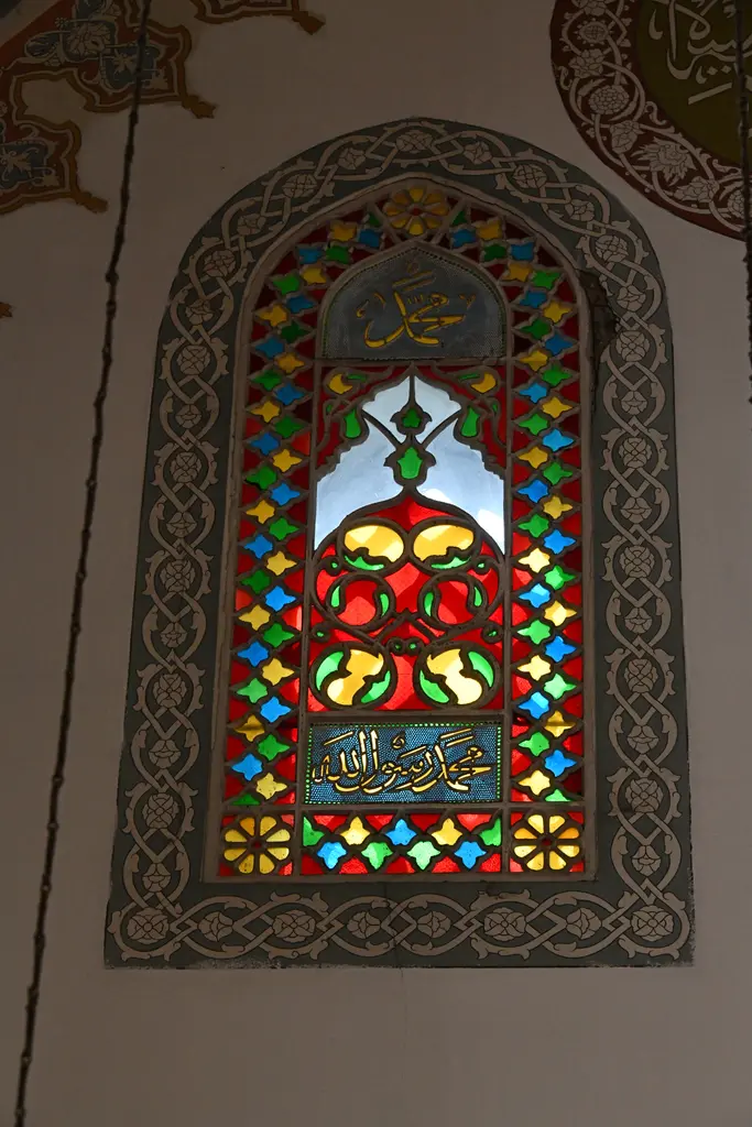 Firuz Ağa Camii'nde renkli camlı pencere; kırmızı, yeşil ve mavi cam parçalar, alçı revzen ve çevresinde kalem işi.
