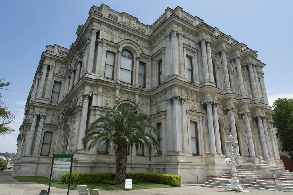 Beylerbeyi Sarayı'nın kara cephesi; aşağıdan bakışla bezemeli üç katlı mermer cephe, palmiye ve giriş merdivenleri.