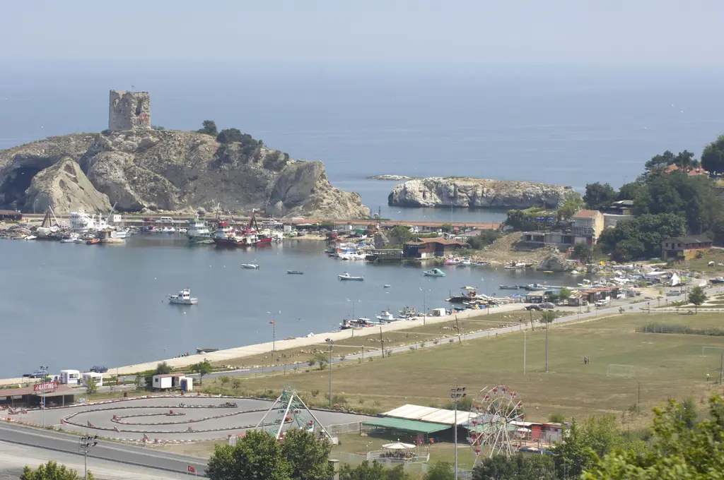 Şile limanı 2007'de; uzakta kayalık adada yıkık kule, önde liman, kıyı yolu, otopark ve yeşil alan.
