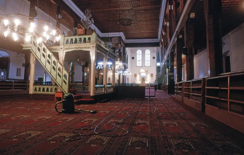 Arap Camii'nin harimi geniş açıyla; yüksek pencereler, ahşap mahfiller, kırmızı halı ve uzakta minber ile mihrap.