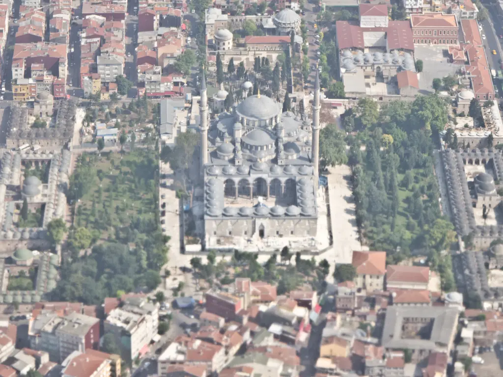 Fatih'te Fatih Külliyesi'nin havadan görünümü; ortada kubbeli cami ile iki minare, solda revaklı avlu, sağda ağaçlı hazire ve iki yanda kubbeli medrese sıraları.