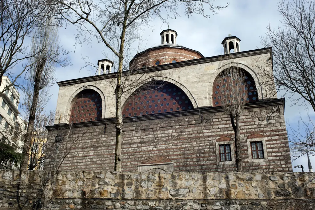 Tophane-i Âmire'de yan yana dizilen kubbeler; fenerli kurşun örtüler, tuğla kasnaklar ve önde taş duvar.