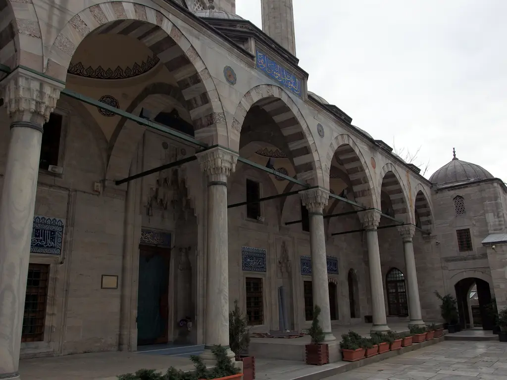 Sokullu Mehmed Paşa Camii'nde avlu revakları; mermer sütunlara oturan sivri kemerler, kemer üstlerindeki çini panolar ve gölgeli galeri.