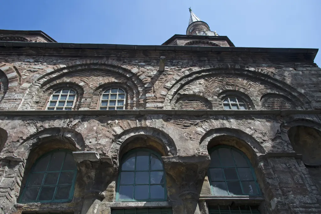 Vefa Kilise Camii'nin cephesine dik yukarı bakış; altta sütunçeler arasında yeşil doğramalı kemerli pencereler, üstte tuğla boşaltma kemerleri ve zikzak tuğla bezeme.
