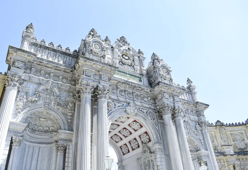 Dolmabahçe Sarayı'nın Hazine Kapısı'ndan ayrıntı; beyaz taşa oyulmuş çiçek ve kıvrık dal motifleri, sütunlar ve kemer.