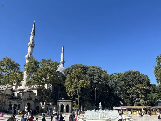 Eyüpsultan'da Eyüp Sultan Camii; ağaçlar arasında yükselen iki ince minare, kubbe ve önündeki meydanda fıskiyeli havuz.