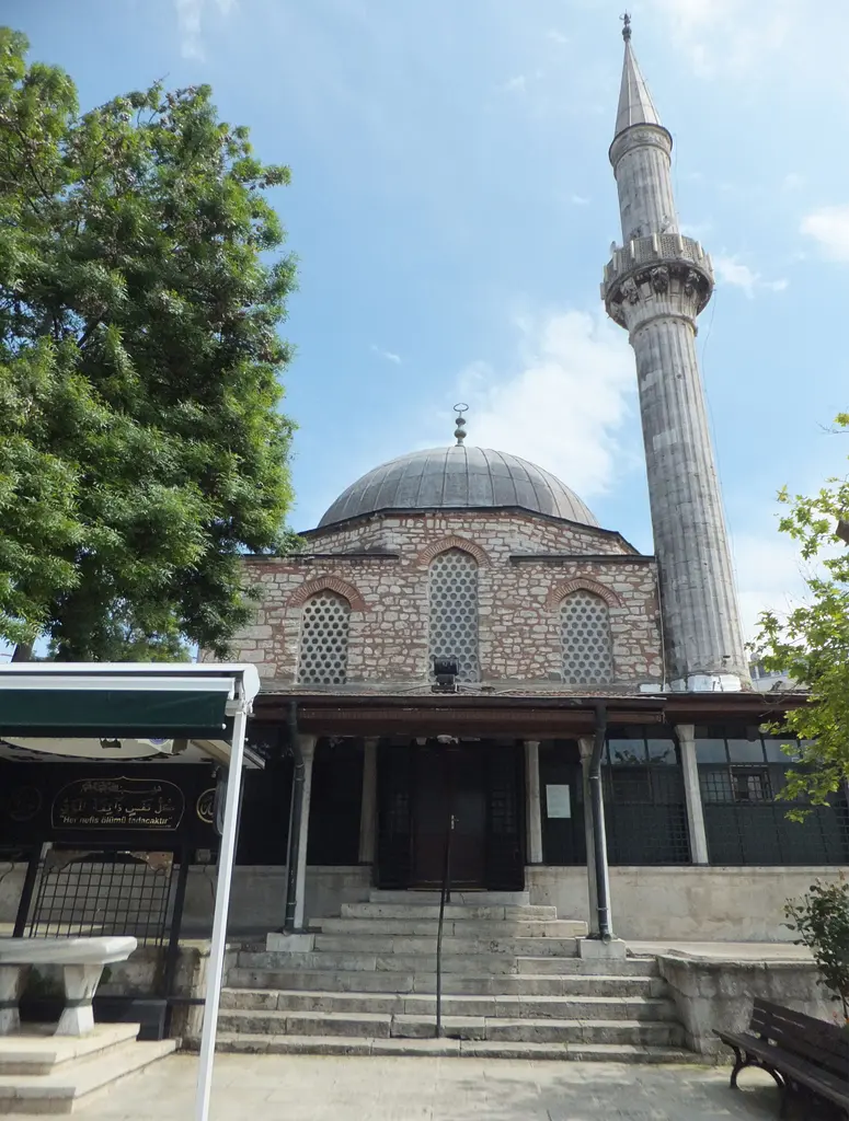 Çinili Camii'nin girişi; geniş taş merdiven, ahşap saçaklı son cemaat yeri, kubbe ve yanında tek minare.