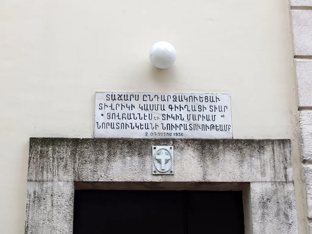 Surp Takavor Kilisesi'nde kitabe; kapı üstünde Ermenice harflerle yazılı mermer levha ve küçük kabartma.