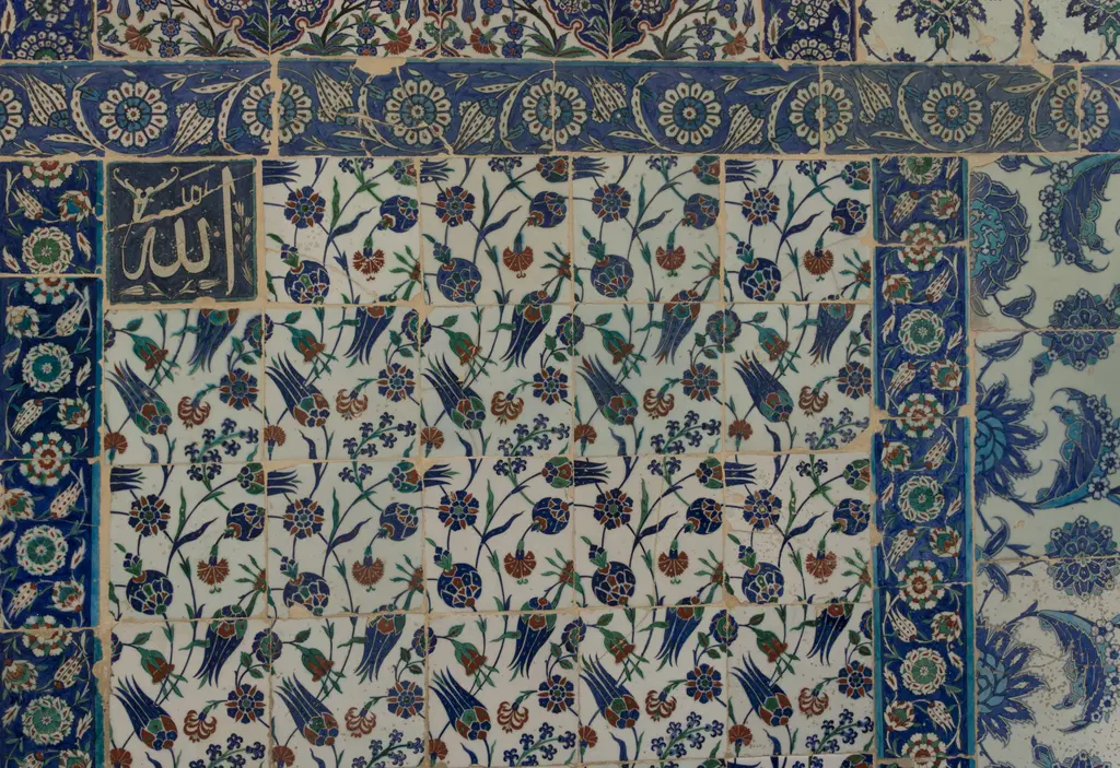 Eyüp Sultan Türbesi'nin dış duvarı; mavi, kırmızı ve yeşil çiçek desenli çiniler, yazı kuşağı ve hat madalyonu.